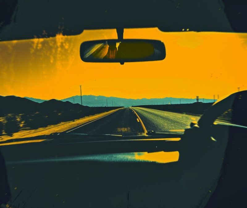 View of a road ahead through the windscreen of a car